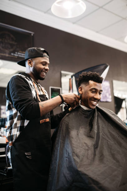 Barber smiling while working with a client